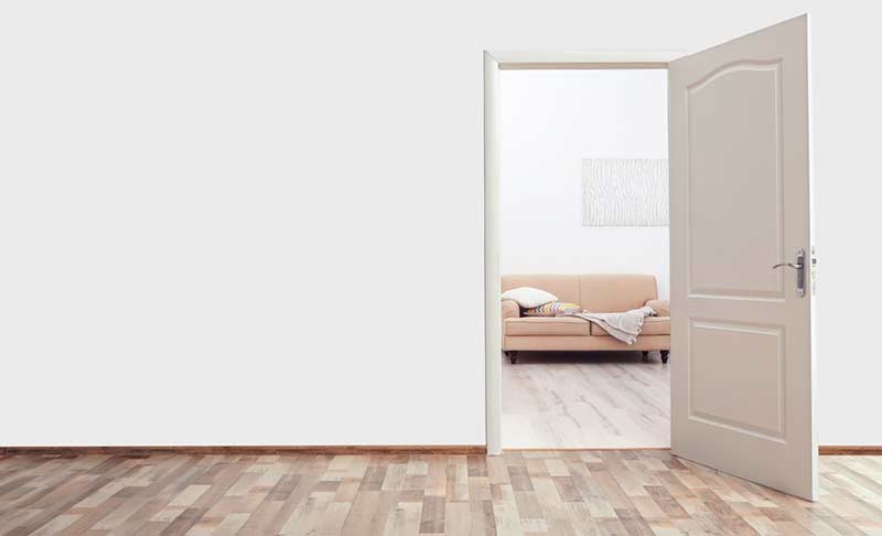 a white wall with an open door to another room